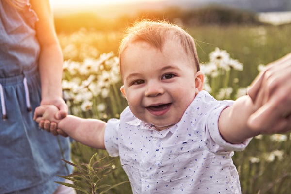 Young child walking with hands holding their hands