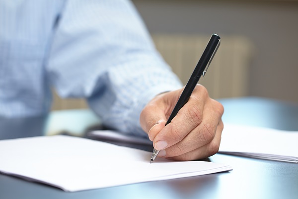 Person writing on a form